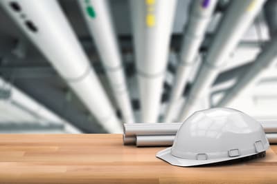 Construction helmet resting on architect drawings