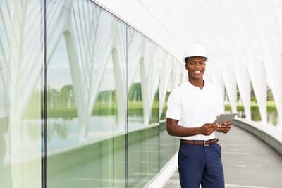 Worker wearing a construction hat and holding a clipboard